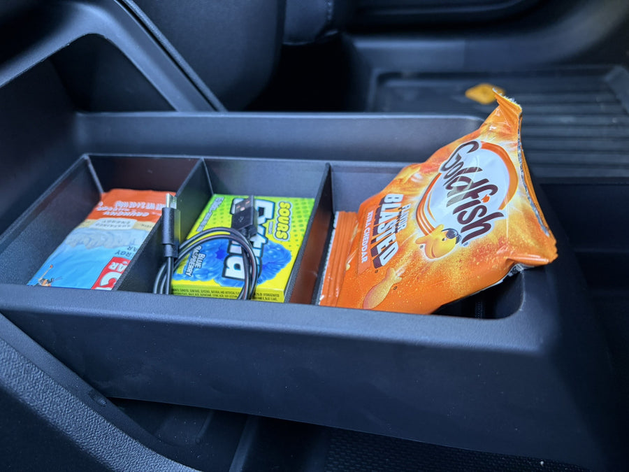 Side view of the Slide-Out Drawer Tray seated in the Rivian R2 drawer beneath the center console